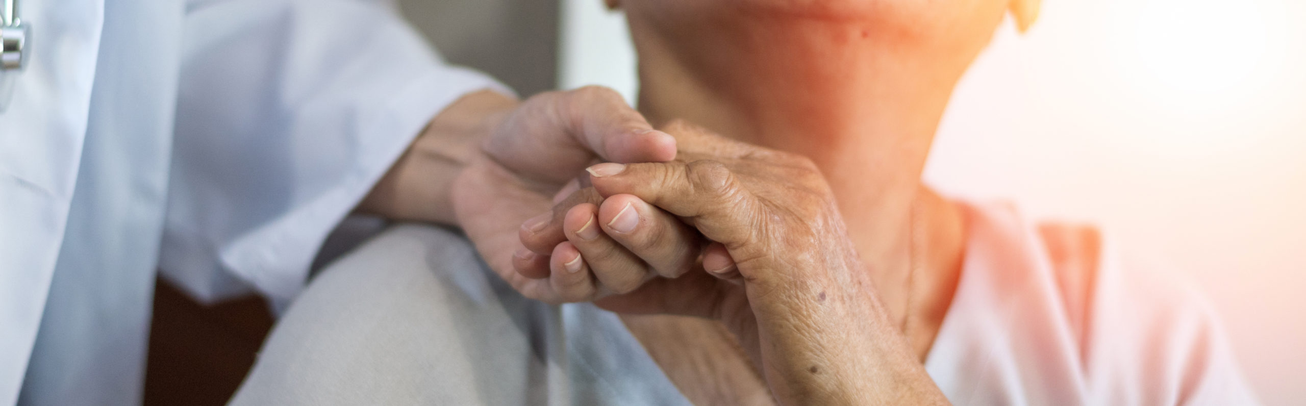 Geriatric doctor or geriatrician concept. Doctor physician hand on happy elderly senior patient to comfort in hospital examination room or hospice nursing home or wellbeing county.