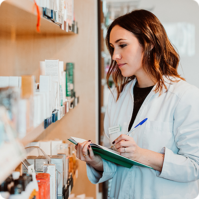 pharmacist with notebook and pen checking inventory