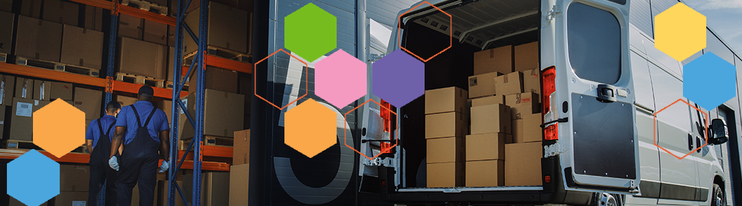 Men in overalls moving boxes in a warehouse to the back of a truck