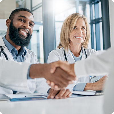 male and female doctor greeting another doctor