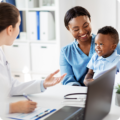 Doctor speaking to a mom who's holding her son